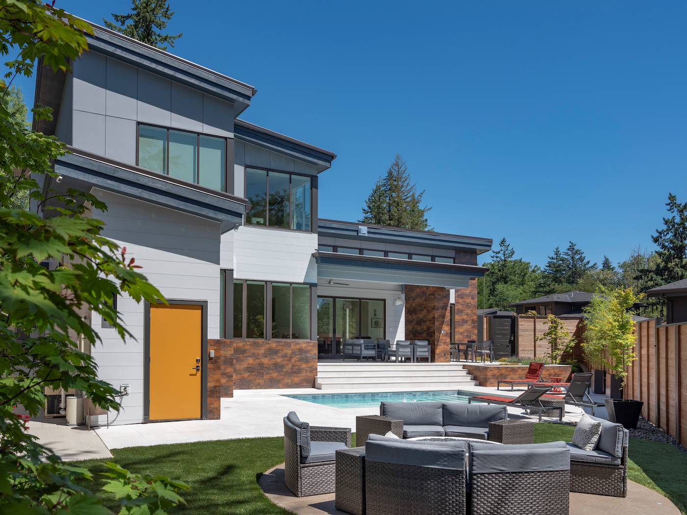 Modern rear exterior of Cumberland House Plan 1496 with pool and outdoor lounge